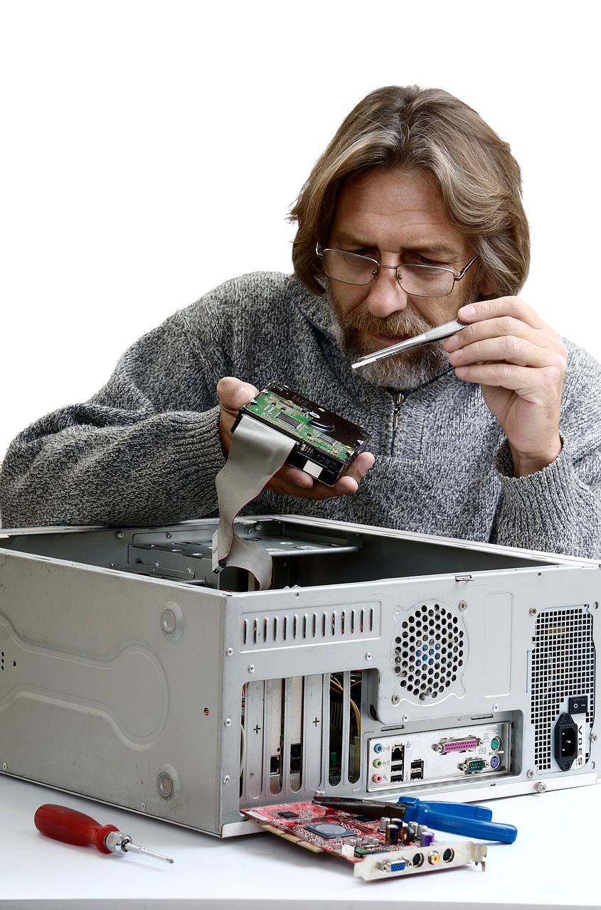 Technician performing detailed computer diagnostic and repair work